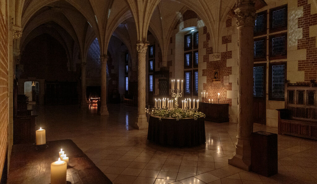 Grande salle du château d'Amboise éclairée à la lumière des chandelles